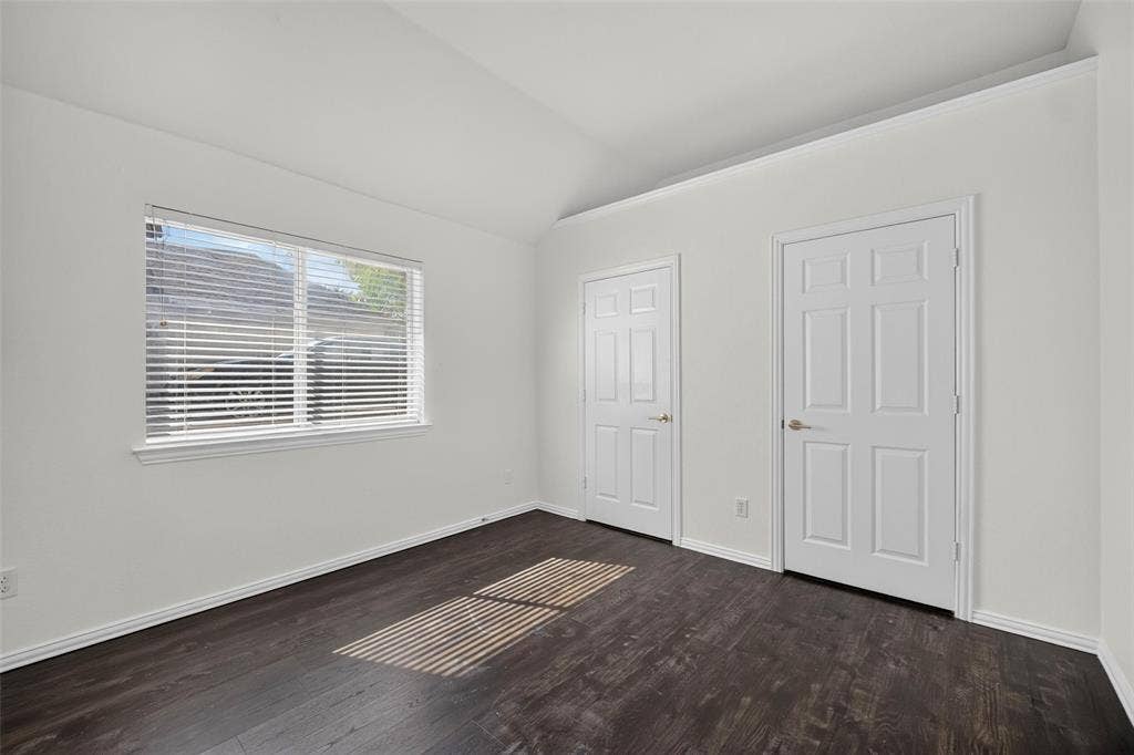 1102 Hartman Court, Arlington, TX 76006 Vaulted ceiling, dark wood-finish flooring, white paneled doors, crown molding, and a window with blinds