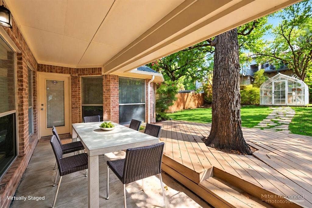1102 Hartman Court, Arlington, TX 76006 Covered patio featuring a brick exterior, outdoor wall sconce, and wood-finish decking