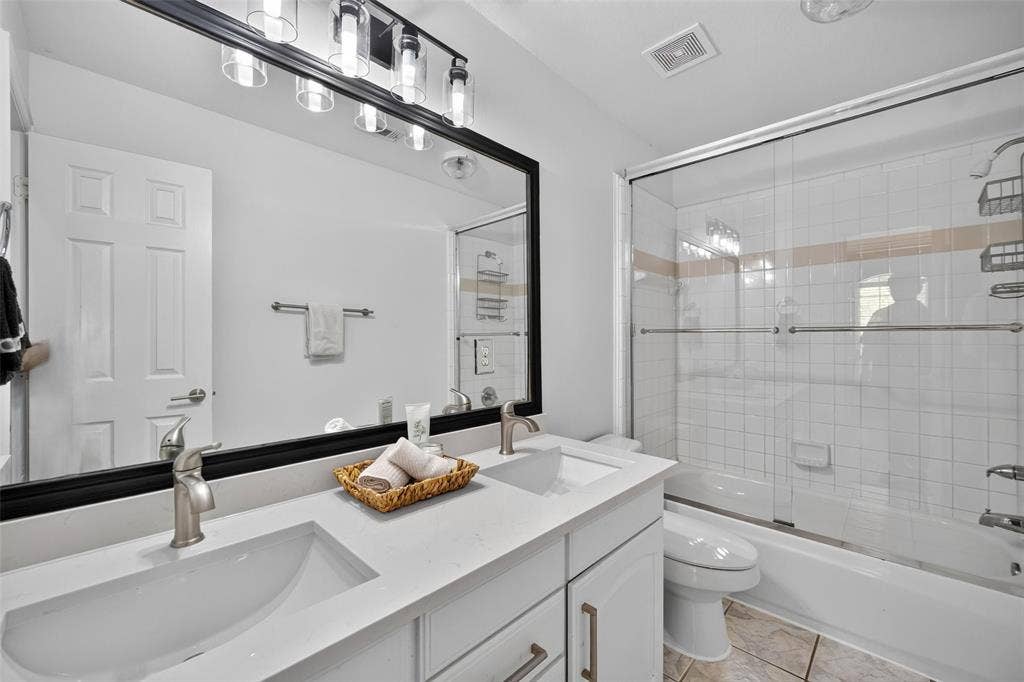 1102 Hartman Court, Arlington, TX 76006 Dual vanity with integrated sinks, brushed nickel faucets, and a large framed mirror