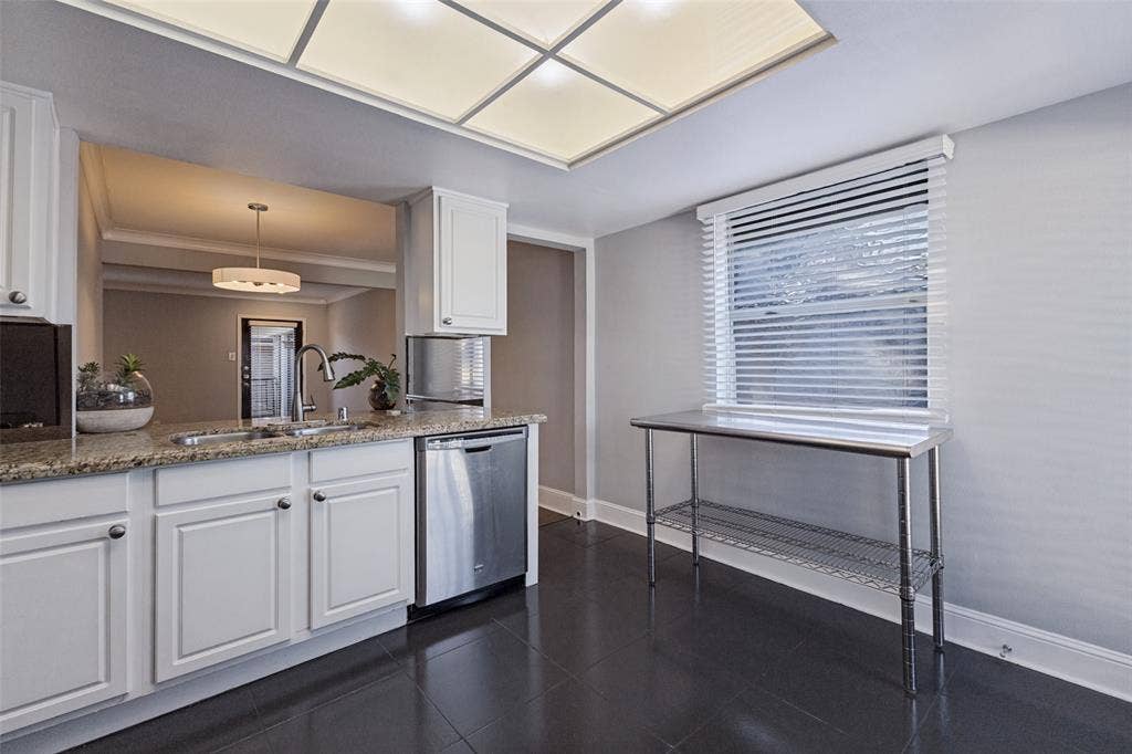 10207 Regal Oaks Drive, #210, Dallas, TX 75230 White cabinetry with stainless steel hardware, a stainless steel dishwasher, and a double basin sink