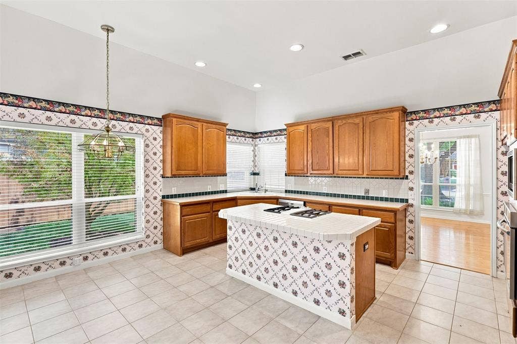 3617 Mackenzie Lane, Richardson, TX 75082 Kitchen featuring wood cabinetry, white tile flooring, a center island with a cooktop, and recessed lighting.
