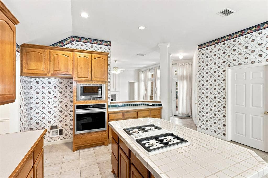 3617 Mackenzie Lane, Richardson, TX 75082 Kitchen featuring a built-in oven, built-in microwave, and wood cabinetry.