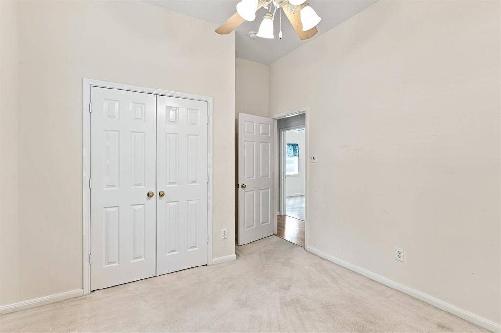 3617 Mackenzie Lane, Richardson, TX 75082 Vaulted ceiling with a ceiling fan, white paneled bifold closet doors, and light-colored wall-to-wall carpeting