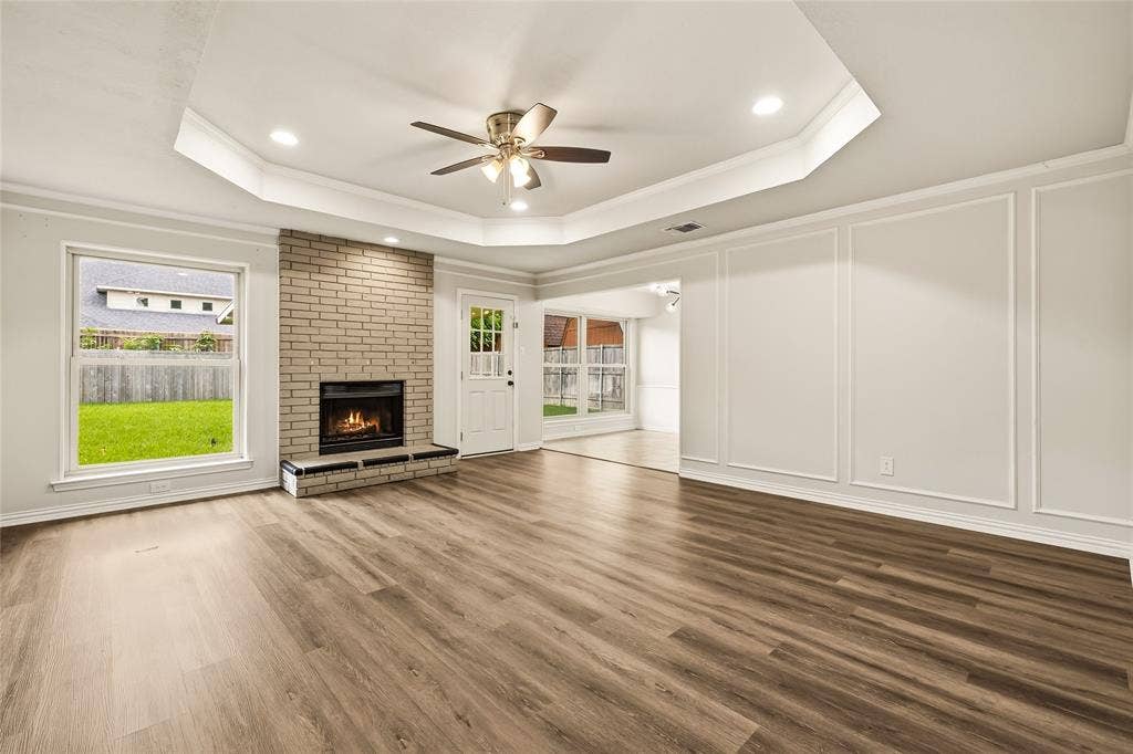 2713 Yale Drive, Rowlett, TX 75088 Expansive living room with large windows, fireplace, and tray ceiling
