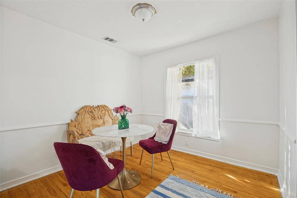 559 Blanning Drive, Dallas, TX 75218 Hardwood flooring, natural light through a single window, white walls, decorative wall trim, and a ceiling-mounted light fixture