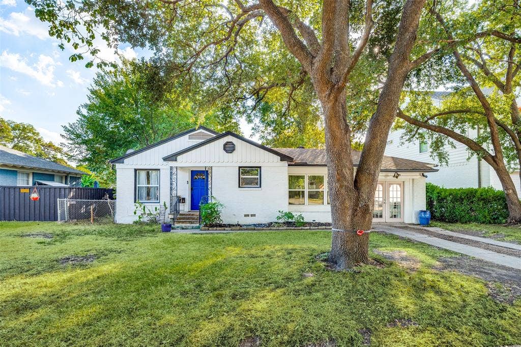 559 Blanning Drive, Dallas, TX 75218 Single-story residence featuring a white exterior, black trim, and a vibrant blue entry door