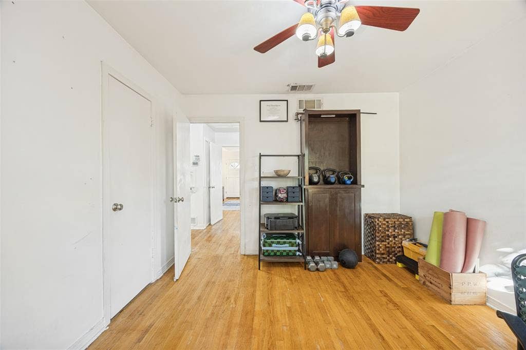 559 Blanning Drive, Dallas, TX 75218 Hardwood flooring, white walls, and a ceiling fan with integrated lighting