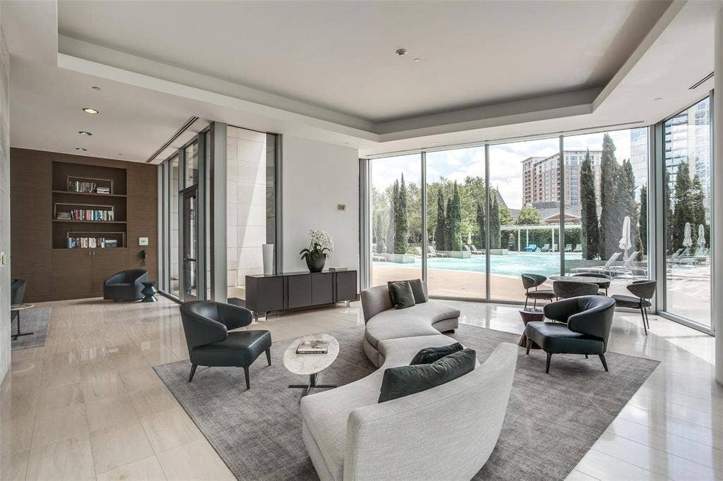 Extensive floor-to-ceiling windows, recessed lighting, built-in shelving, wood-finish wall panels, and a polished tile floor