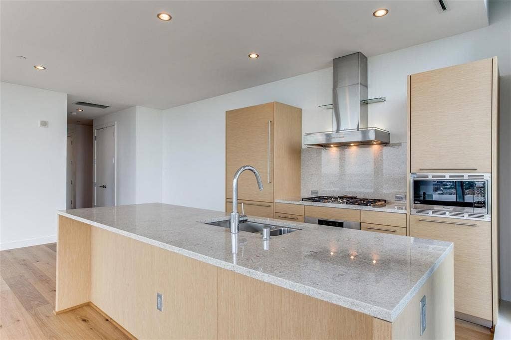 Kitchen featuring a central island with an undermount sink, light-toned wood-finish cabinetry, stainless steel appliances, a gas cooktop, and recessed lighting