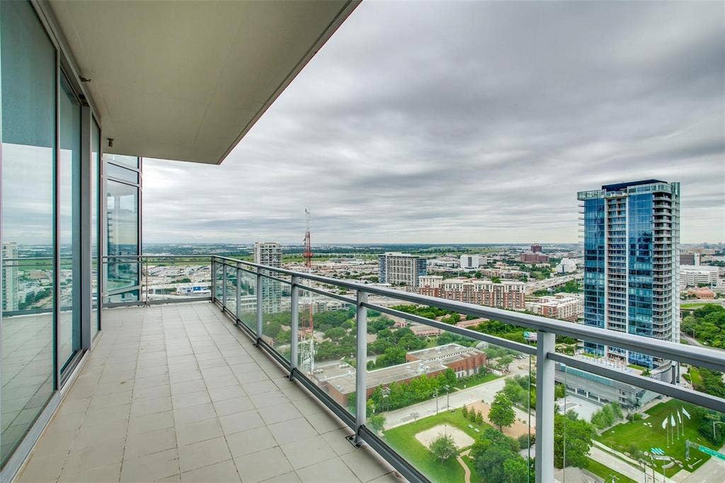 Balcony featuring tiled flooring and a glass panel railing