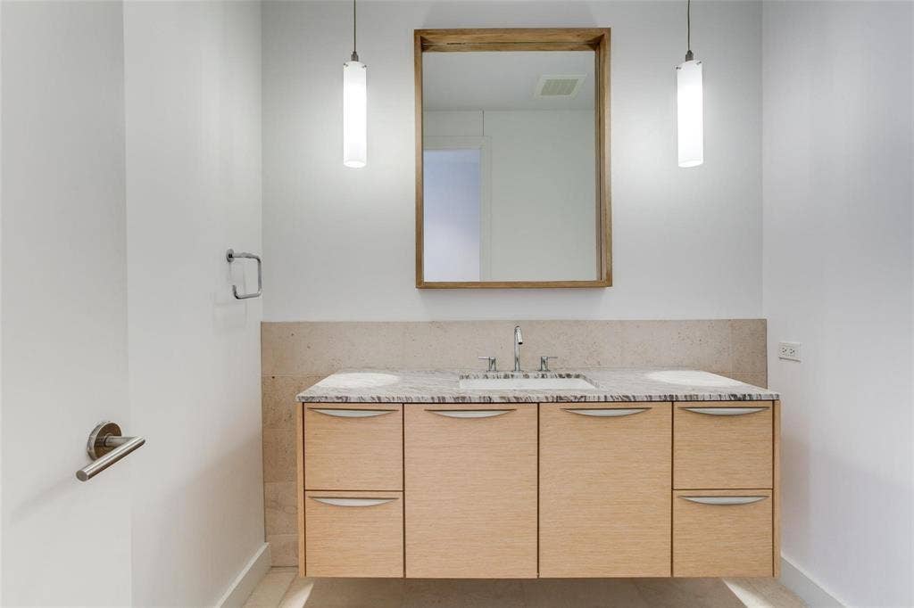 Floating wood-finish vanity with dual undermount sinks and a stone-finish countertop