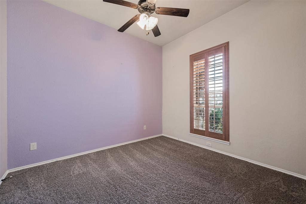 Vaulted ceiling, ceiling fan with light fixture, carpeted flooring, and window with wood plantation shutters