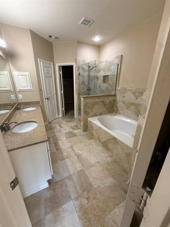 10012 Castlewood Drive, Plano, TX 75025 Dual vanity with undermount sinks, stone-finish countertops, and white cabinetry