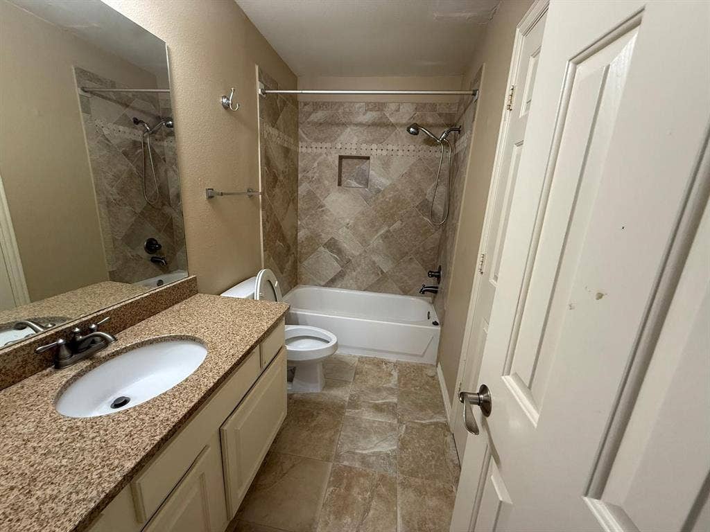 10012 Castlewood Drive, Plano, TX 75025 Bathroom featuring a vanity with an oval sink, textured countertop, and lower cabinetry