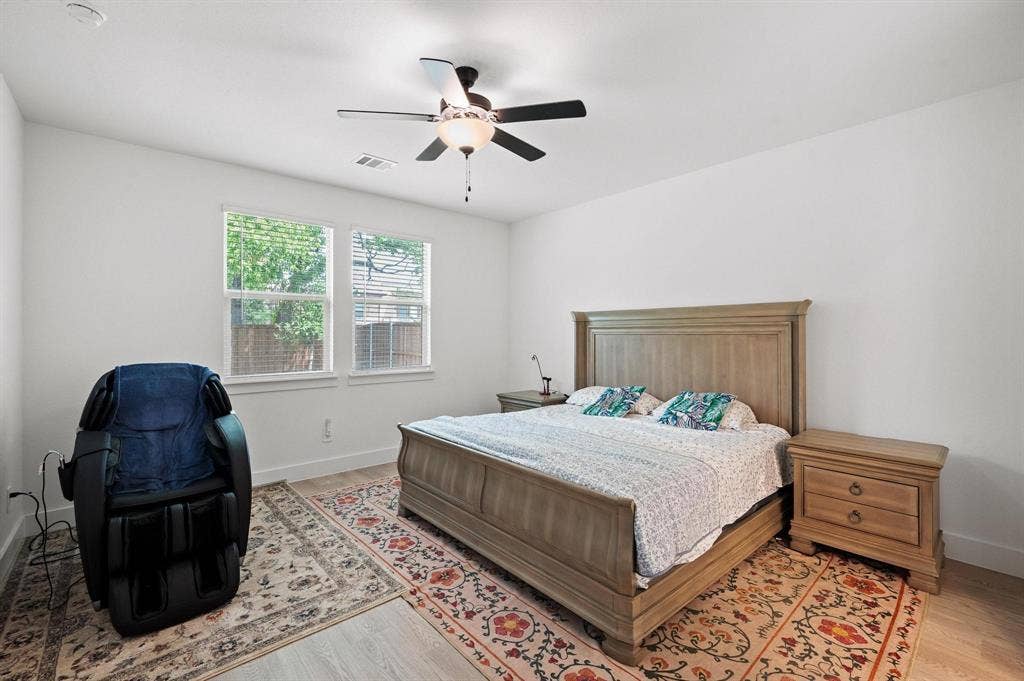 Recessed ceiling lighting, two large windows, ceiling fan with light fixture, light wood-finish flooring