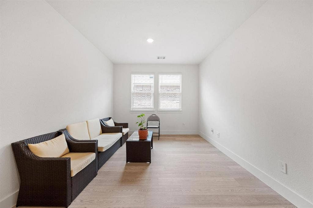 Recessed ceiling lighting, light wood-finish flooring, and white walls
