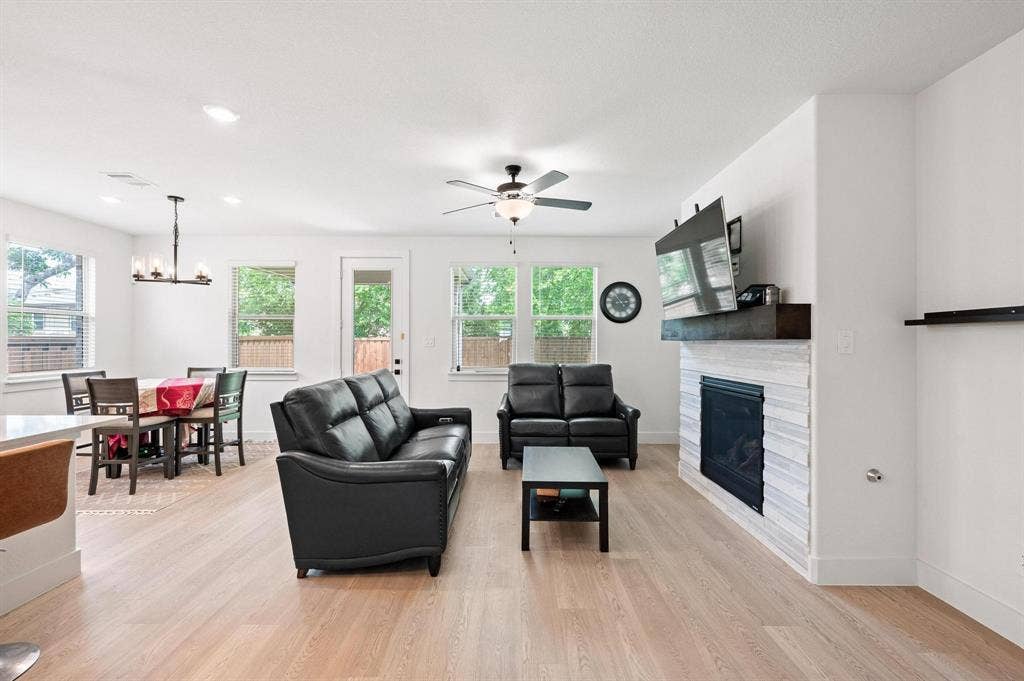 Open-concept living space with light wood-finish flooring, a contemporary ceiling fan, and recessed lighting