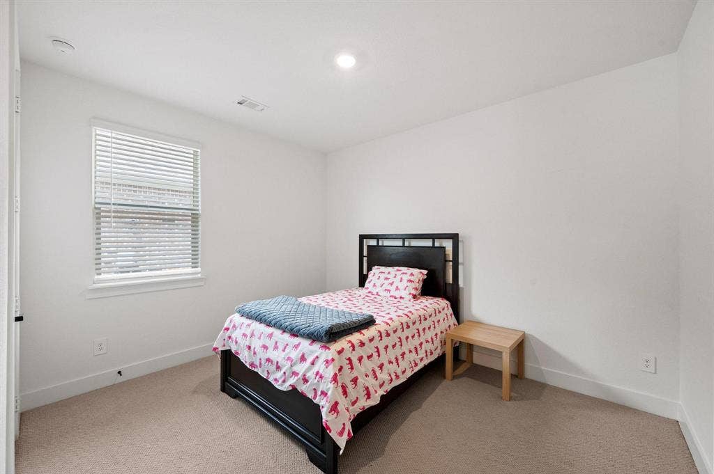 Recessed ceiling lighting, white walls, window with blinds, carpeted flooring, and a white ceiling