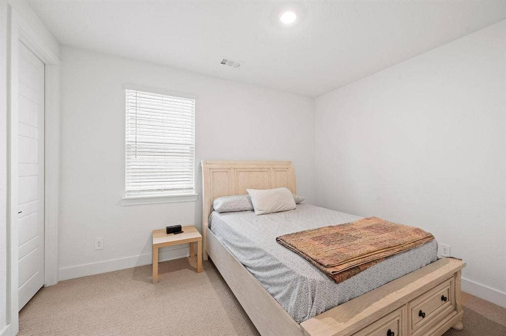 Recessed ceiling lighting, window with blinds, panel closet door, light-toned carpet flooring, and neutral wall finishes