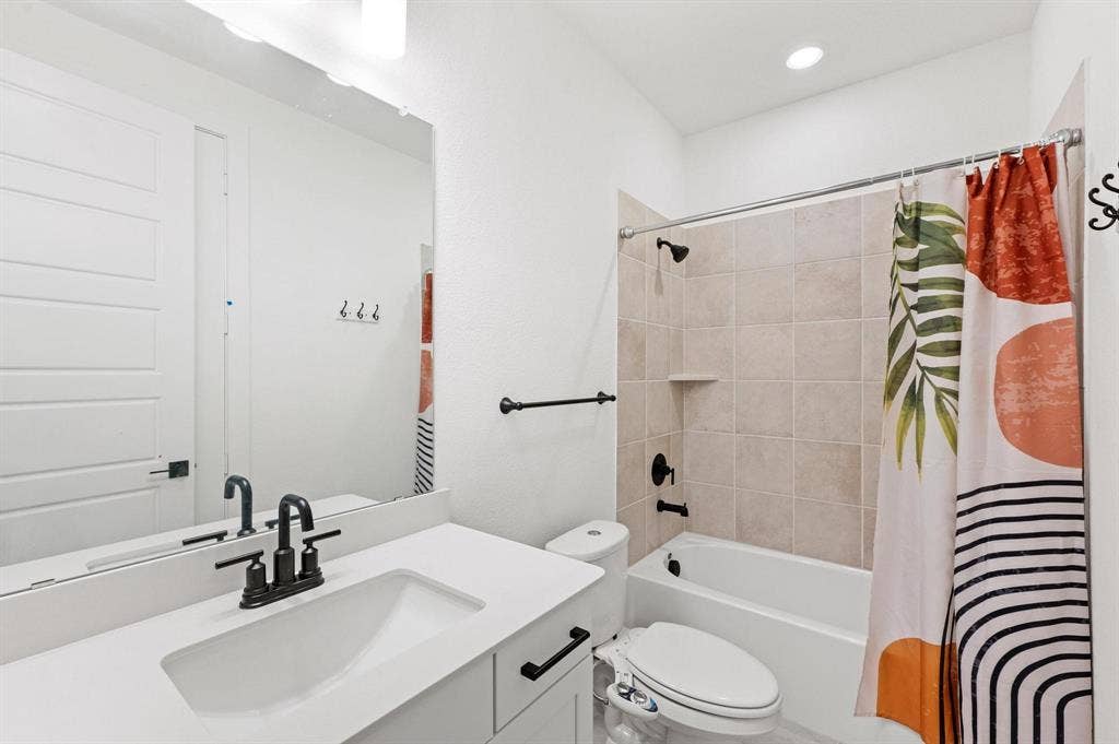 Vanity with integrated sink, black hardware, and large mirror