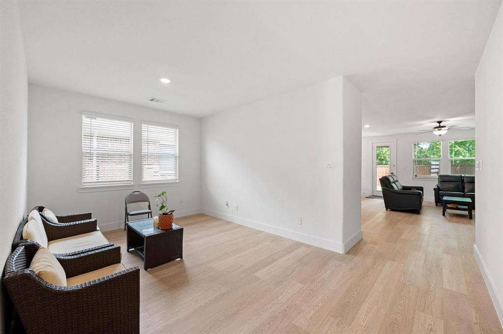 Recessed lighting, wood-finish flooring, white walls, and multiple windows with blinds