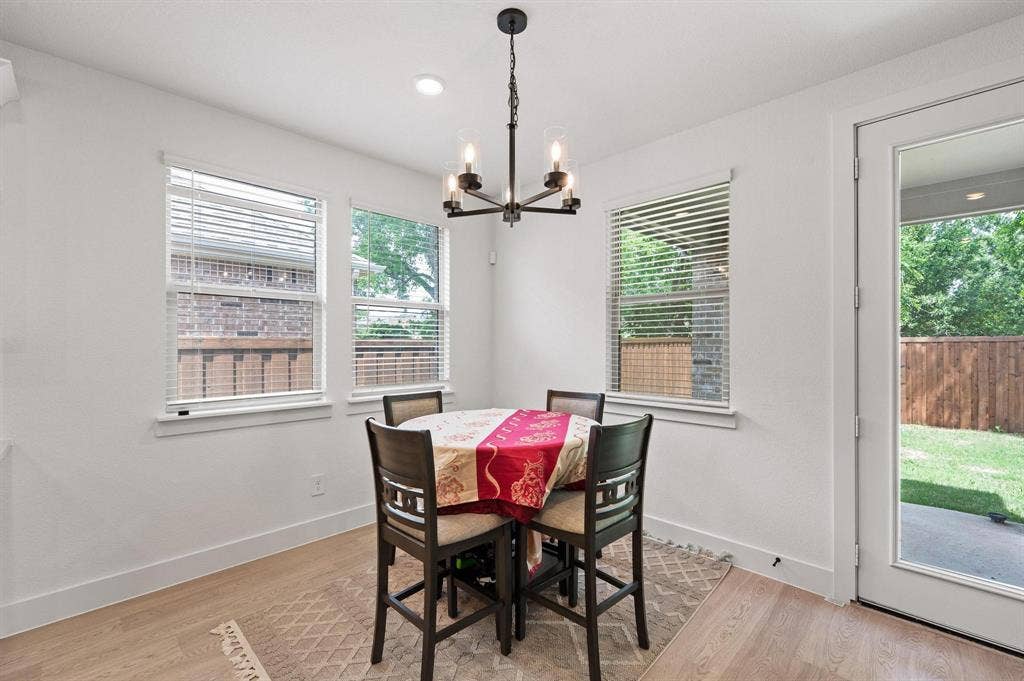Wood-finish flooring, recessed lighting, and a modern chandelier