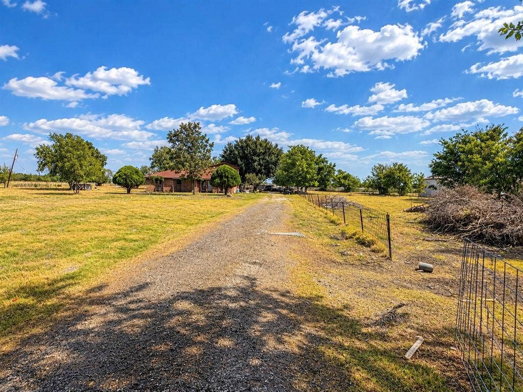 2429 Neck Road, Palmer, TX 75152 Gravel driveway with a partial fence line and scattered mature trees
