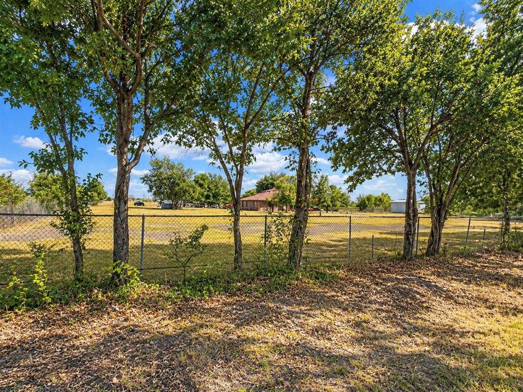 2429 Neck Road, Palmer, TX 75152 Chain link fencing bordering a grassy area with mature trees