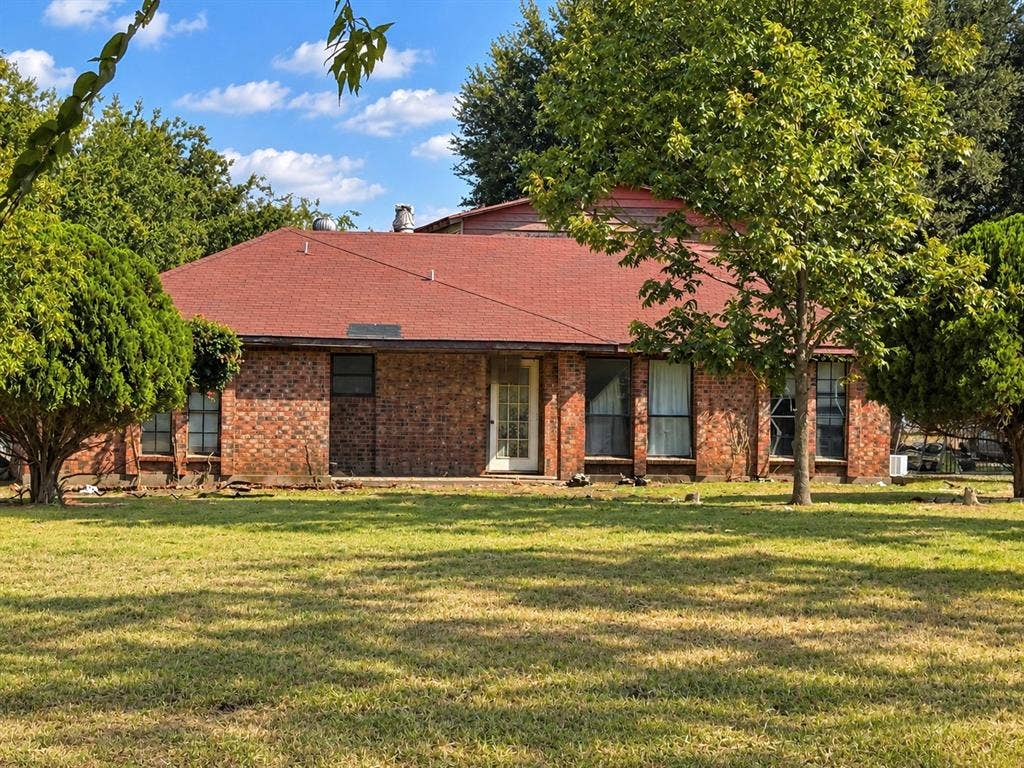 2429 Neck Road, Palmer, TX 75152 Brick exterior with multiple windows, a red shingle roof, and established landscaping