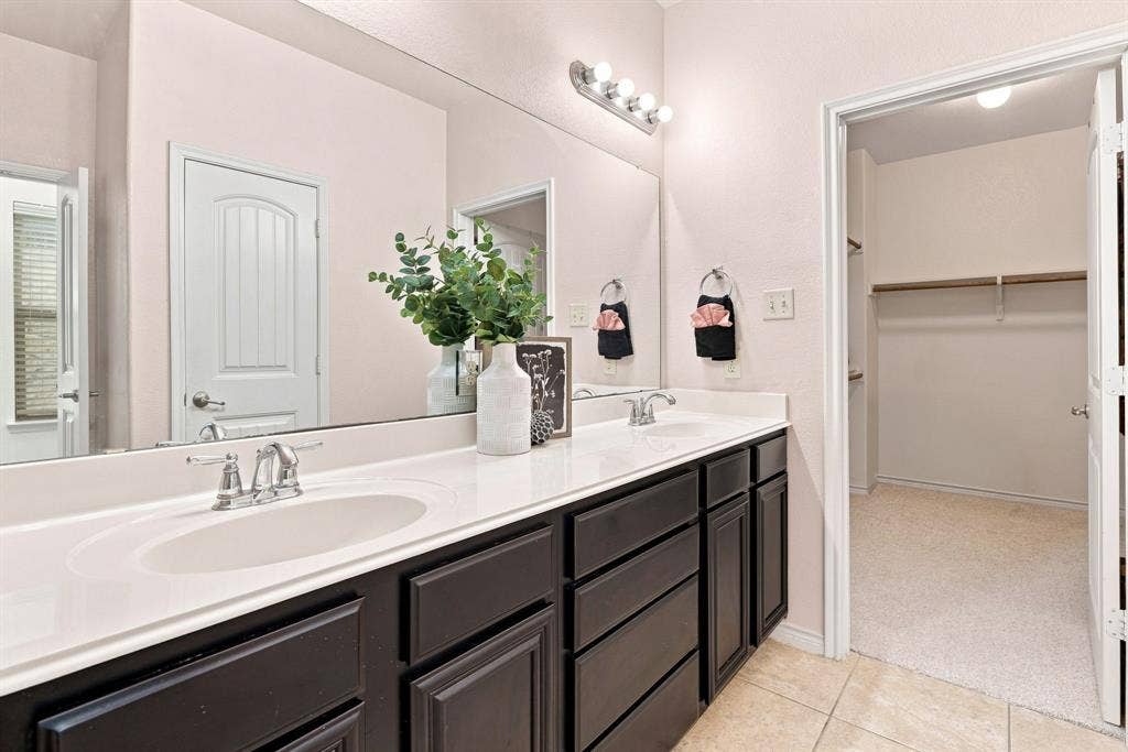 5605 Cojimar Drive, McKinney, TX 75070 Double vanity with integrated sinks, dark wood-finish cabinetry, and polished chrome fixtures