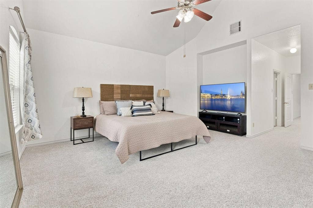 5605 Cojimar Drive, McKinney, TX 75070 Vaulted ceiling with a ceiling fan, light gray carpeting, and a built-in media niche