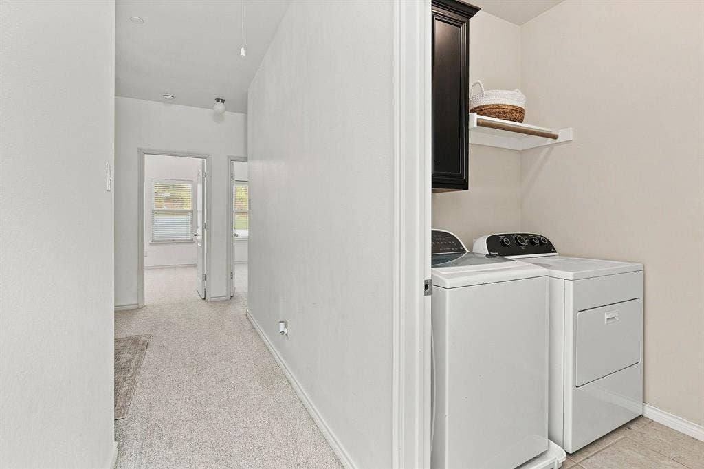 5605 Cojimar Drive, McKinney, TX 75070 Laundry area featuring a dark wood-finish cabinet and an open shelving unit with a hanging rod