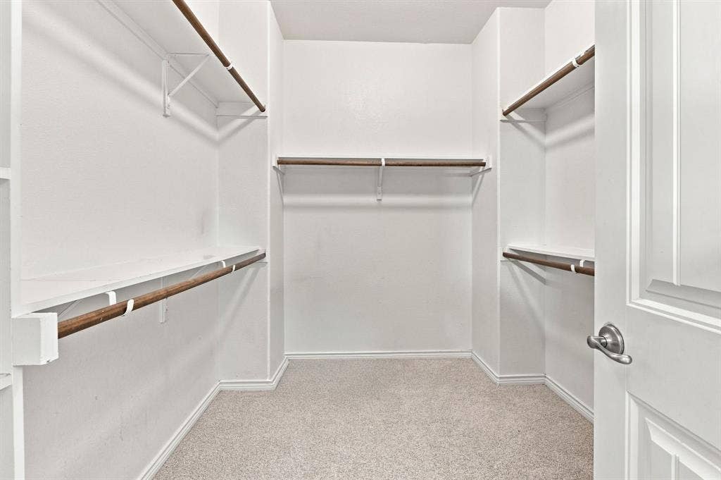 5605 Cojimar Drive, McKinney, TX 75070 Carpeted walk-in closet with multiple built-in shelves and hanging rods