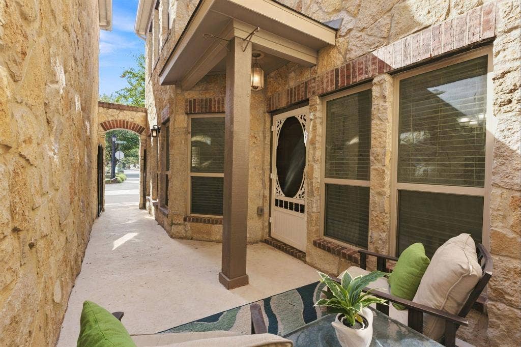 5605 Cojimar Drive, McKinney, TX 75070 Stone exterior with brick accents, covered patio, arched passageway, and a decorative front door