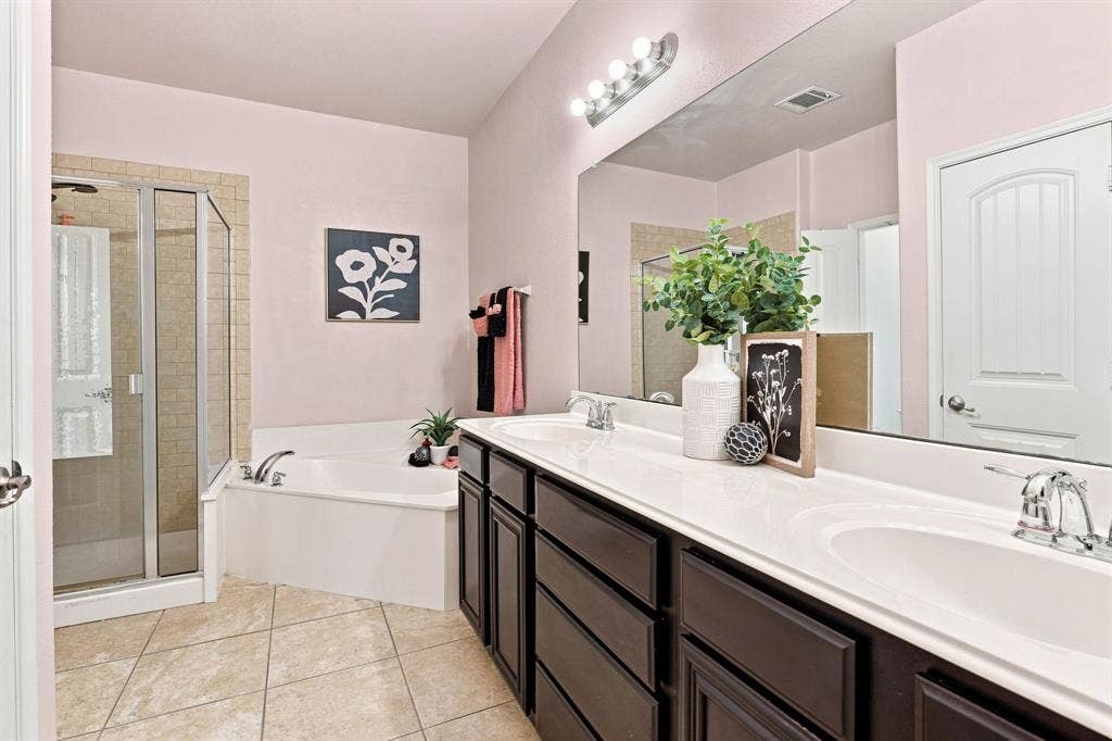 5605 Cojimar Drive, McKinney, TX 75070 Dual vanity with white countertop, chrome fixtures, and dark wood-finish cabinetry