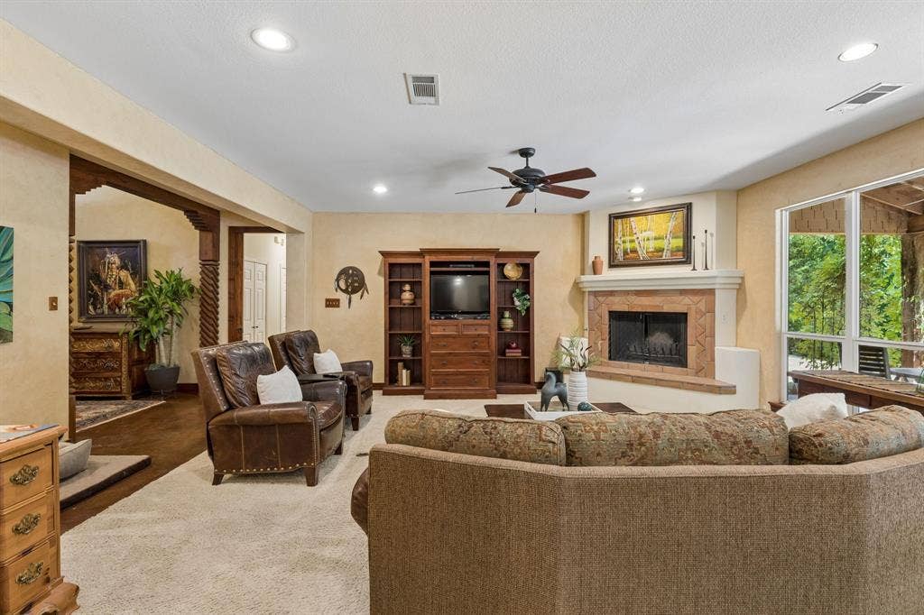 3227 Berry Hollow, Melissa, TX 75454 Spacious living area featuring a fireplace with a stone surround, a ceiling fan, recessed lighting, and large windows