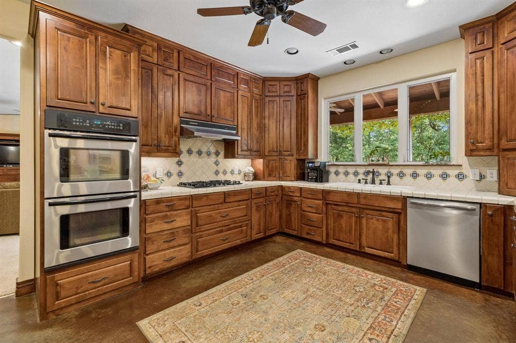 3227 Berry Hollow, Melissa, TX 75454 Kitchen featuring extensive wood cabinetry, stainless steel double ovens, a gas range with a decorative tile backsplash, a built-in dishwasher, and recessed lighting