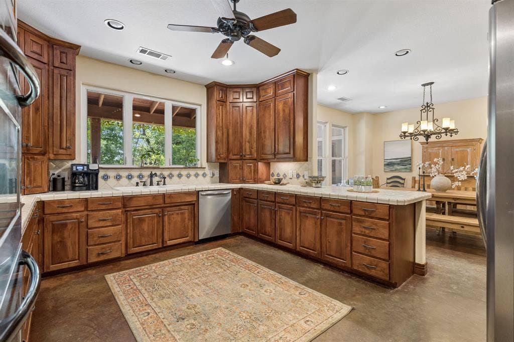 3227 Berry Hollow, Melissa, TX 75454 Wood-finish cabinetry, tile countertops, recessed lighting, ceiling fan, and stainless steel dishwasher