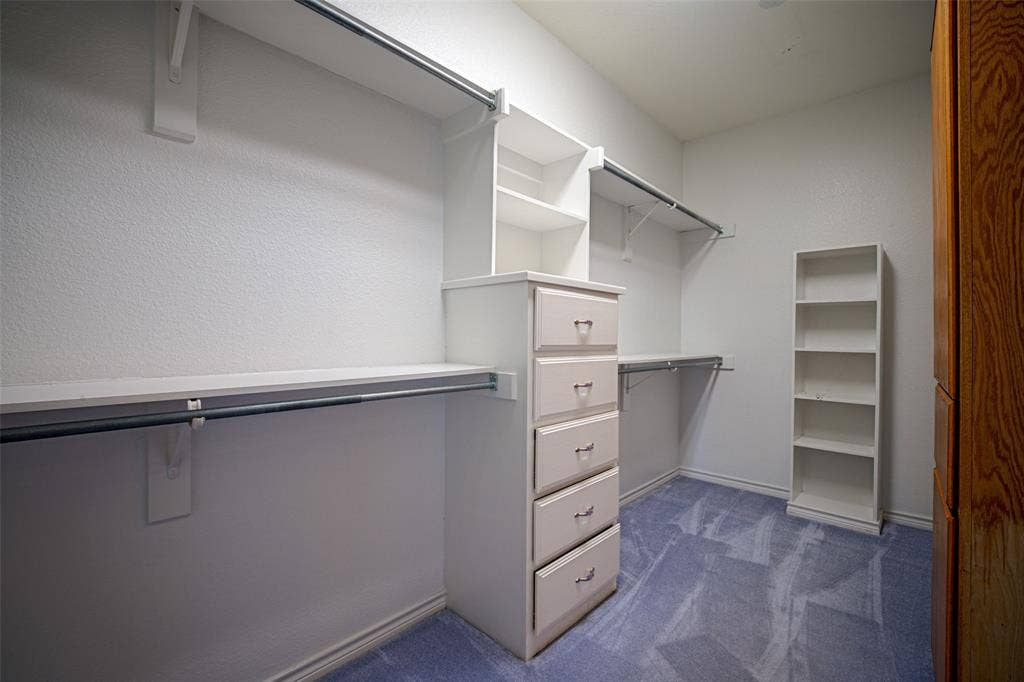 Built-in closet system featuring shelving, hanging rods, and a five-drawer dresser
