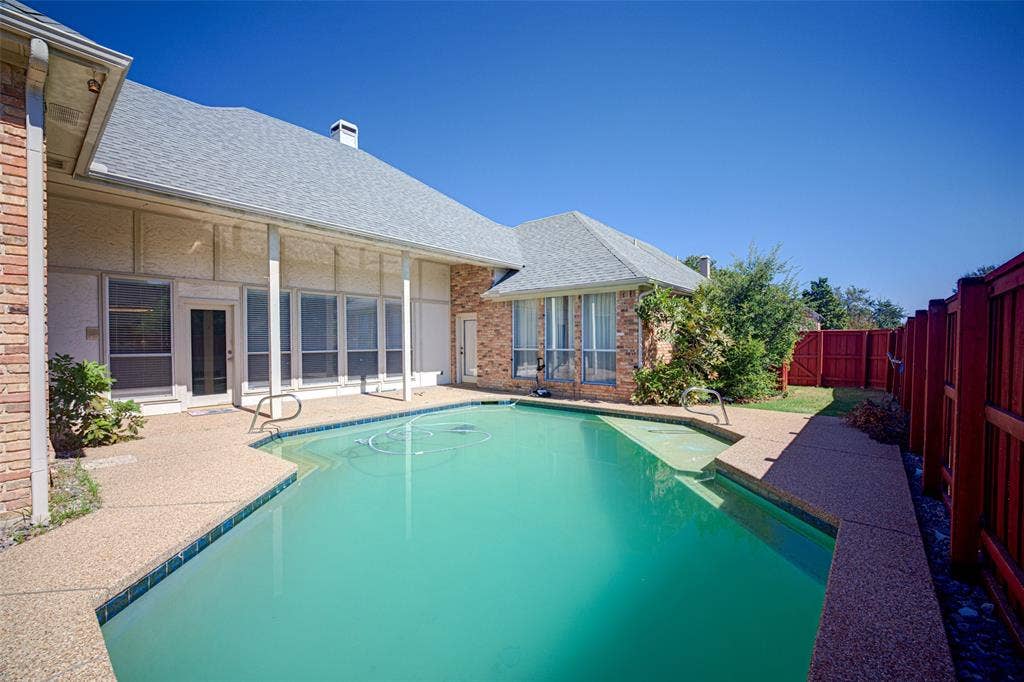 Private outdoor pool with a surrounding aggregate concrete patio