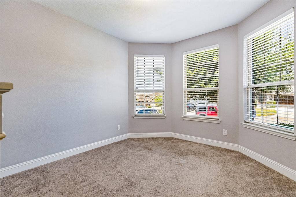 1004 Baynes Drive, McKinney, TX 75071 Three large windows with blinds, light gray walls, and carpet flooring