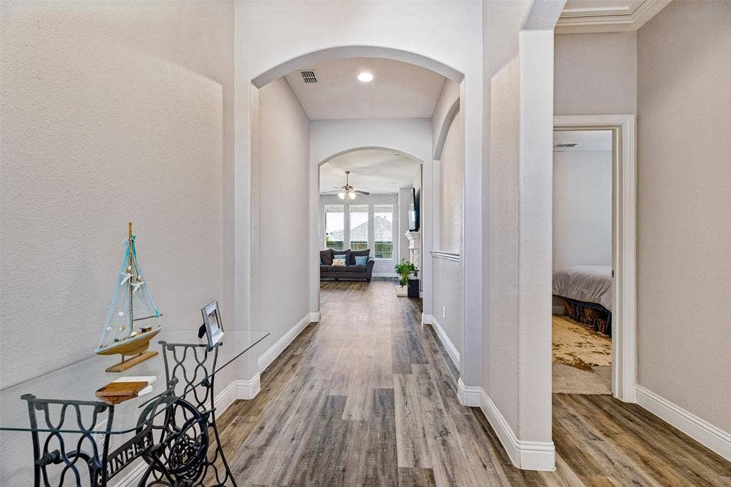 1004 Baynes Drive, McKinney, TX 75071 Wood-finish flooring throughout, arched doorways, and crown molding