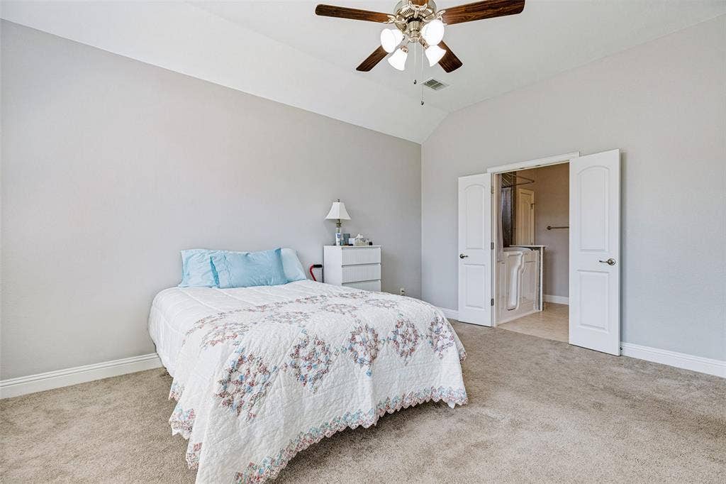 1004 Baynes Drive, McKinney, TX 75071 Vaulted ceiling, ceiling fan with light fixture, carpet flooring, double doors, and a built-in walk-in tub