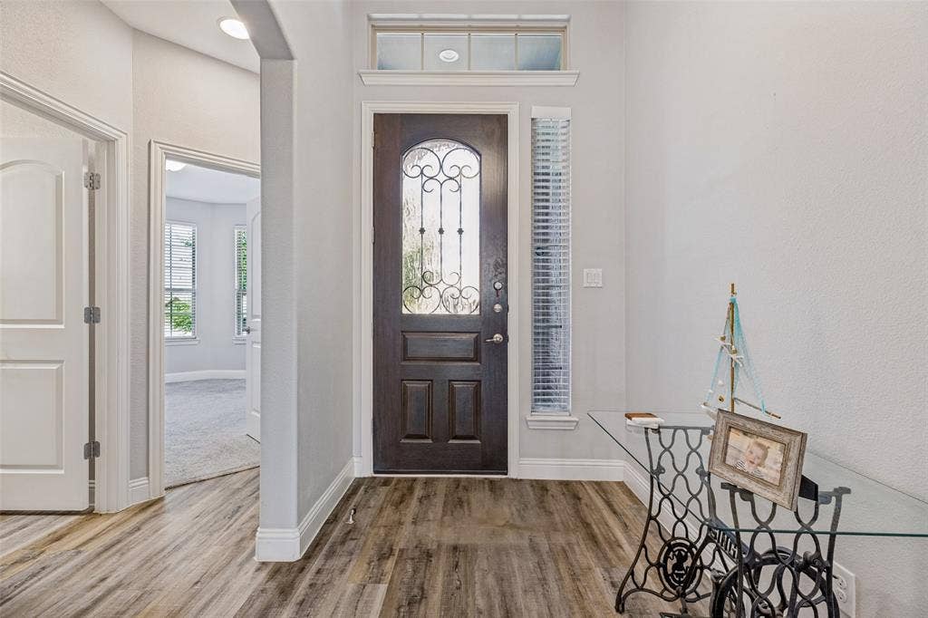 1004 Baynes Drive, McKinney, TX 75071 Dark wood-finish entry door with decorative glass and sidelight