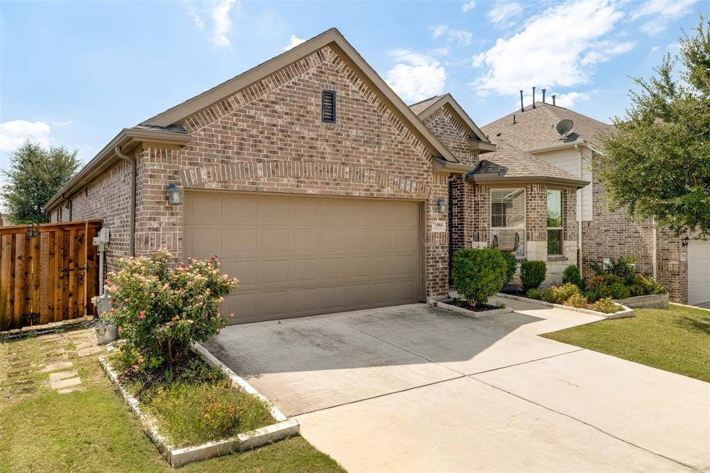 1004 Baynes Drive, McKinney, TX 75071 Brick facade with stone accents, attached garage, concrete driveway, and a front yard with established landscaping
