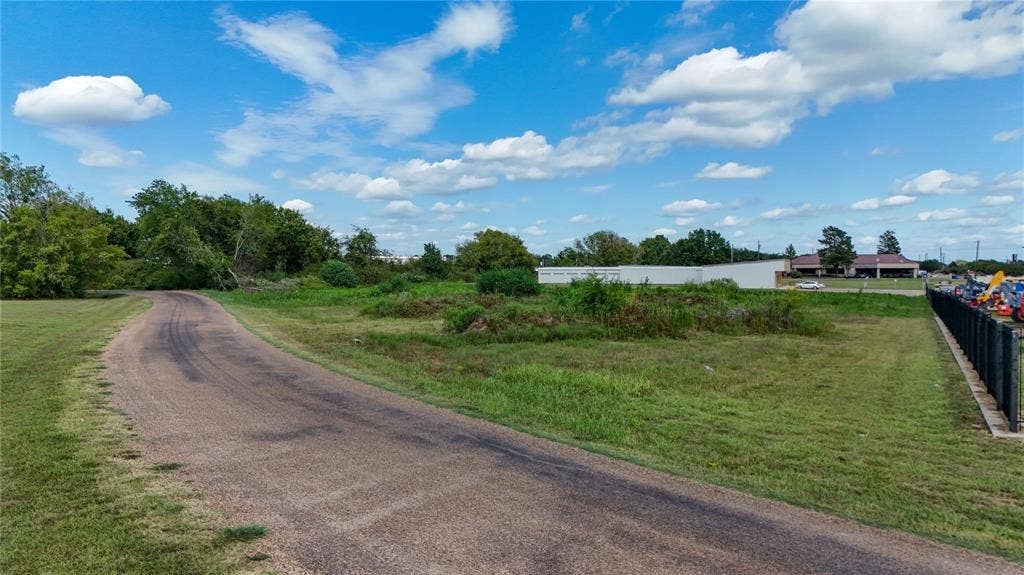 101 Lea Dr, Gun Barrel City, TX 75156 Paved access road, extensive green space, mature trees, security fence, and distant commercial buildings