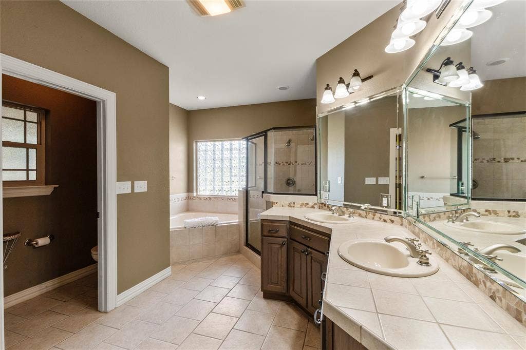 Primary bathroom with dual sinks and separate tub and shower