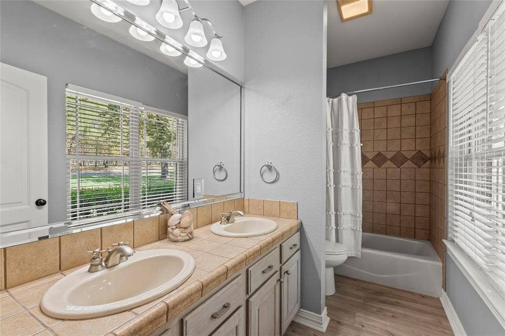 2nd primary bathroom with dual sinks and tile tub and shower combo.