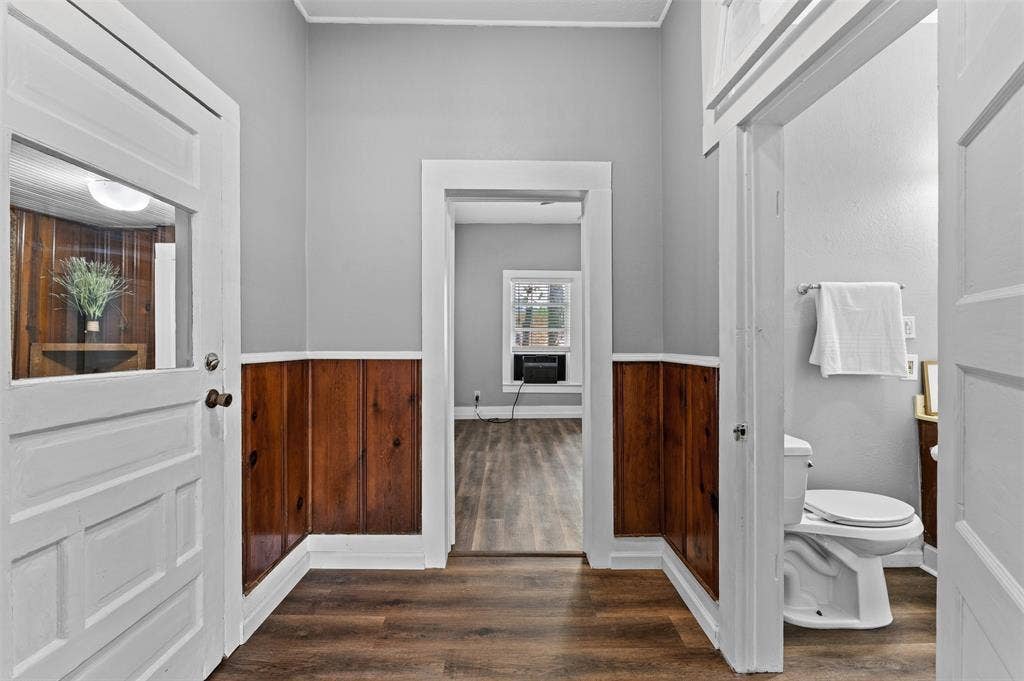 302 W Broadway Street, West, TX 76691 Wood-finish flooring, half-wall wainscoting, and a white toilet