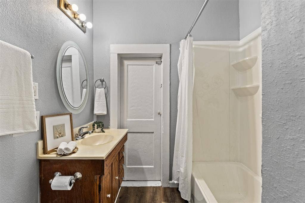 302 W Broadway Street, West, TX 76691 Bathroom featuring a vanity with wood-finish cabinetry, a built-in sink, and an oval mirror